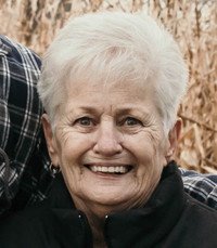 Smiling older woman with short white hair.