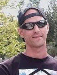 Person outdoors wearing sunglasses and cap.