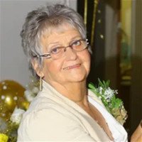 Smiling elderly woman wearing glasses, holding flowers