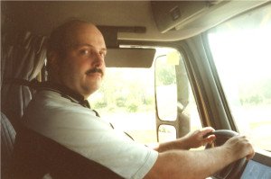 Truck driver smiling inside vehicle cab