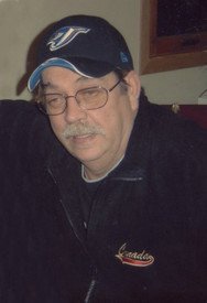 Man wearing glasses and a baseball cap indoors.