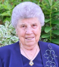 Elderly woman smiling in garden with greenery