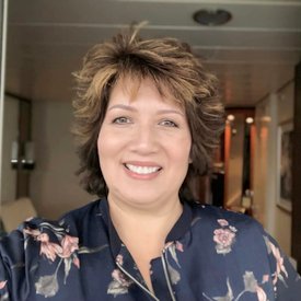 Smiling woman in floral blouse, indoor setting