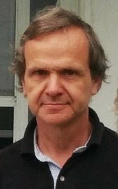 Man in black shirt standing outside.