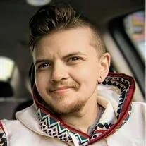 Smiling person wearing patterned hoodie in a car