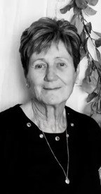 Elderly woman smiling in black and white portrait.