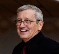 Smiling elderly man in glasses and dark suit