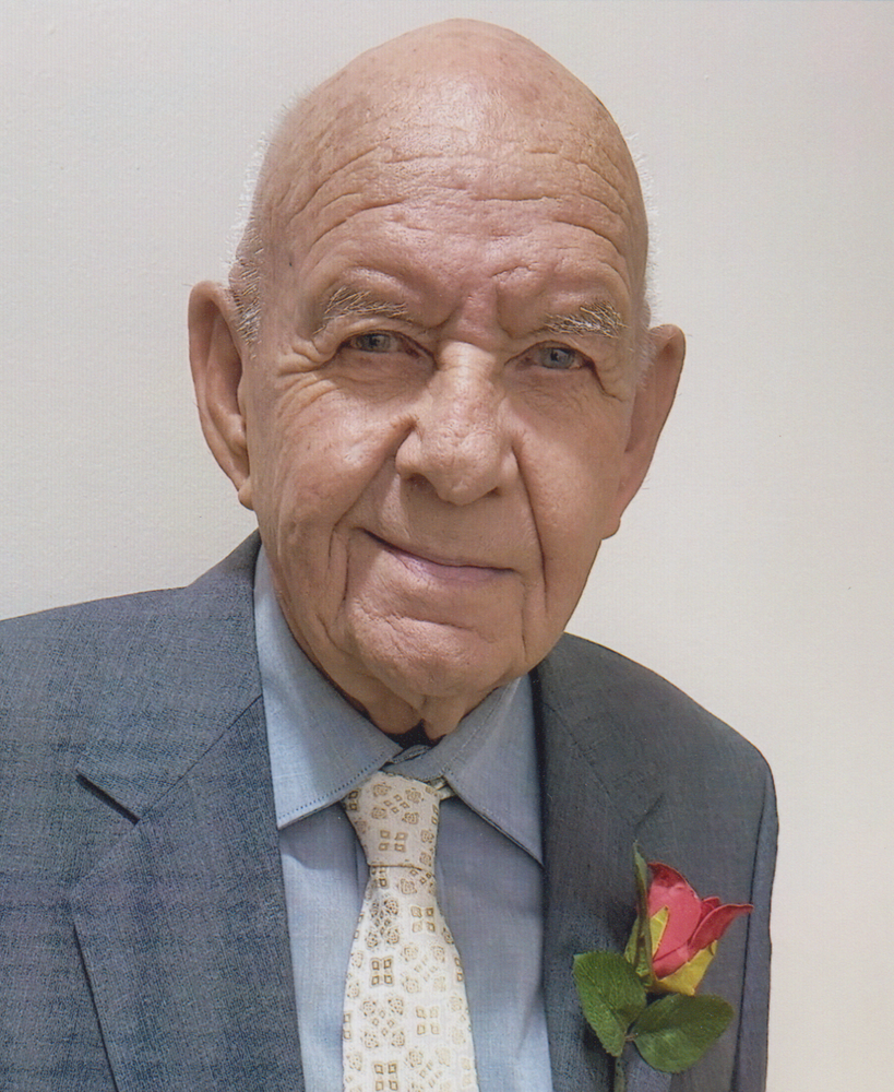 Elderly man in suit with rose boutonnière.