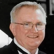 Smiling man in formal attire with glasses.