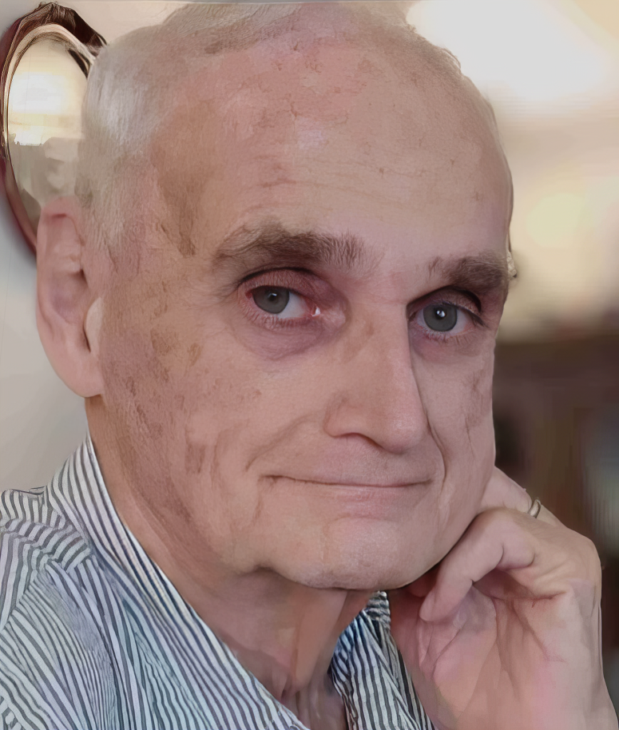 Elderly man with striped shirt smiling gently.