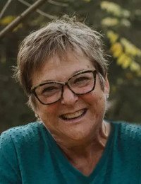 GIGG, Deborah Ruth Gigg Smiling woman with glasses outdoors.