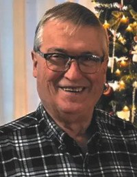 Smiling man wearing glasses near Christmas tree