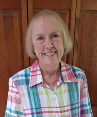 Smiling woman in plaid shirt indoors