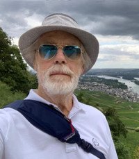 Man in hat near scenic river and village view