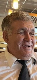 Smiling man wearing a tie in a restaurant.