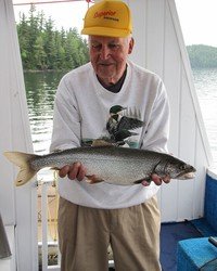 Elderly man holding a freshly caught fish.