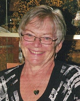 Smiling person with short hair and glasses