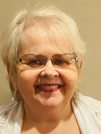 MELARANGELI, Donna Evelyne Melarangeli Smiling person with glasses and short white hair.