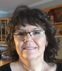 Smiling woman with glasses in a kitchen