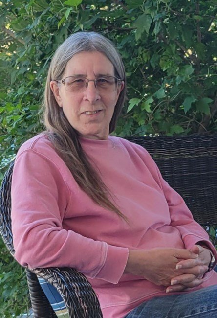 Person sitting outside in chair, green background