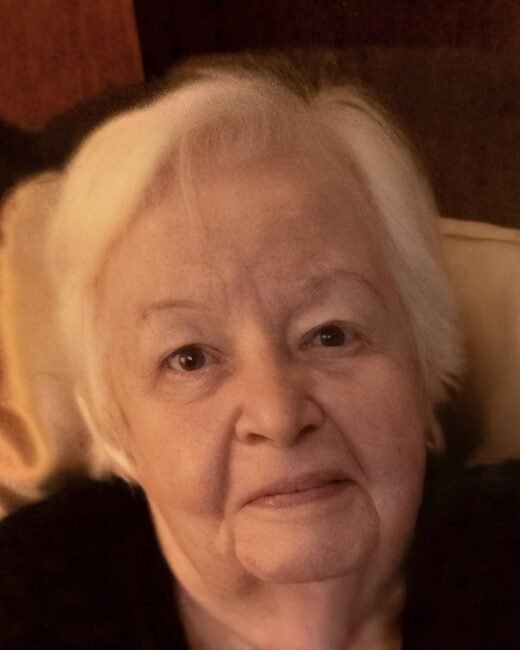 Elderly woman with white hair smiling warmly.