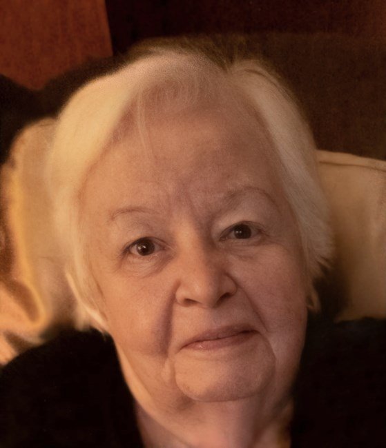 Elderly woman with white hair smiling warmly.