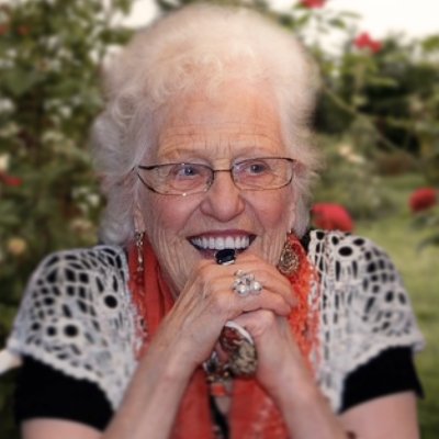 Smiling elderly woman outdoors with flowers background