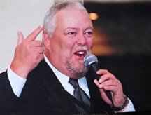 Man speaking into microphone passionately at event.