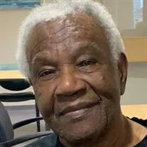 Smiling elderly man with white hair indoors.