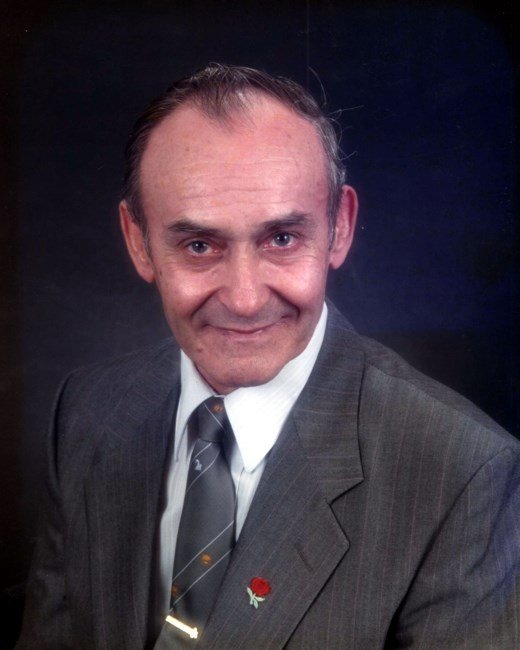Elderly man in suit smiling at camera.
