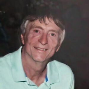 Smiling man in a light green shirt.