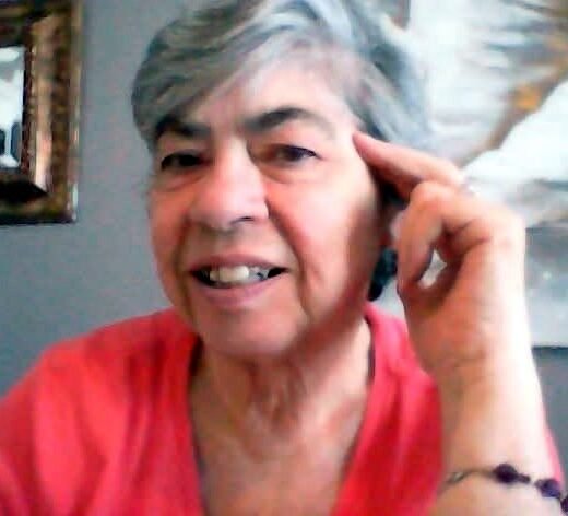 Smiling woman with gray hair and pink shirt.
