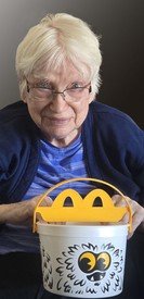 Elderly person holding a Halloween-themed McDonald's bucket.