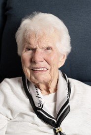Smiling elderly woman with white hair and scarf.