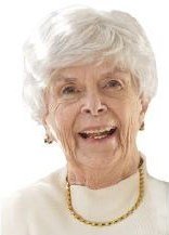 Smiling elderly woman with white hair and necklace.