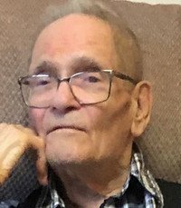 Elderly man with glasses and thoughtful expression.