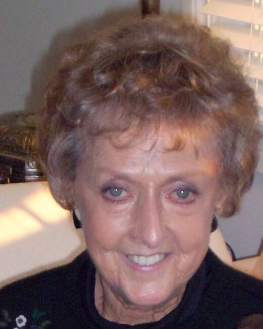 Smiling elderly woman indoors with curly hair.