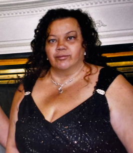 Woman in black dress with curly hair.