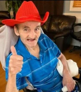 Man in red hat giving thumbs up, smiling