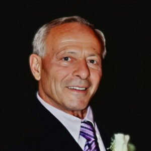 Elderly man in suit smiling at event