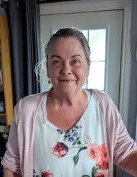 Smiling woman in floral dress by door