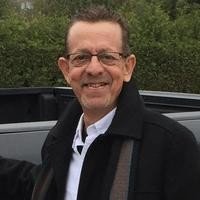 Smiling man outside near greenery