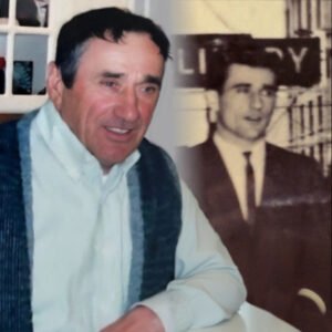 Man smiling beside historical photo of himself
