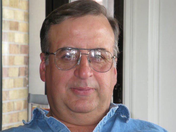 HENRY, Mario Joseph Paul Lewis Henry Middle-aged man wearing glasses and denim shirt.