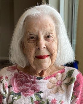 Elderly woman smiling in floral sweater