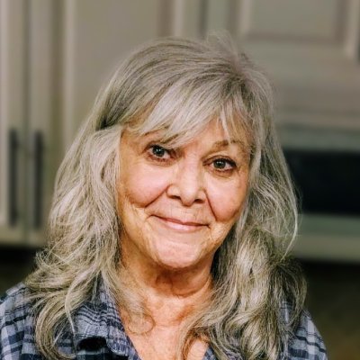 Smiling older woman with gray hair indoors.