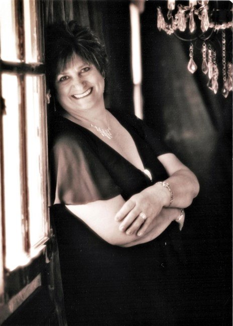 Smiling woman leaning against wall, elegant setting.