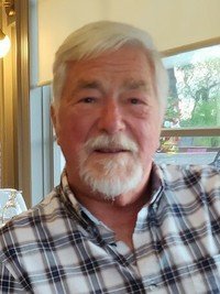 Elderly man with white beard and plaid shirt