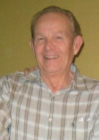 Smiling elderly man in plaid shirt indoors