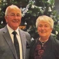 THOMPSON , Frederick Thompson Smiling elderly couple in front of Christmas tree.